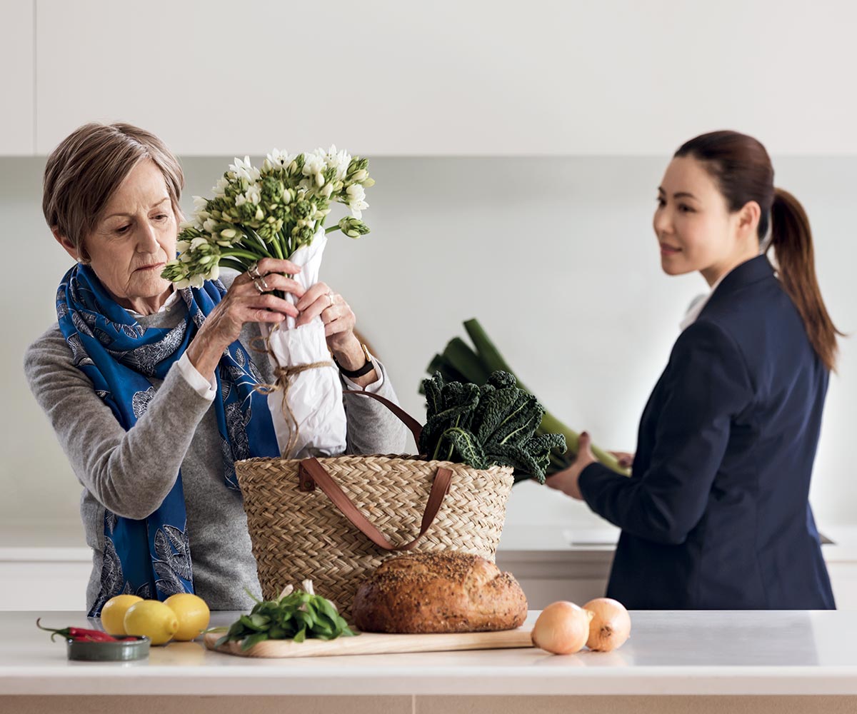 Assistant helping woman unpack grocery shopping. If you need it, support is available at Pavilions Blackburn Lake